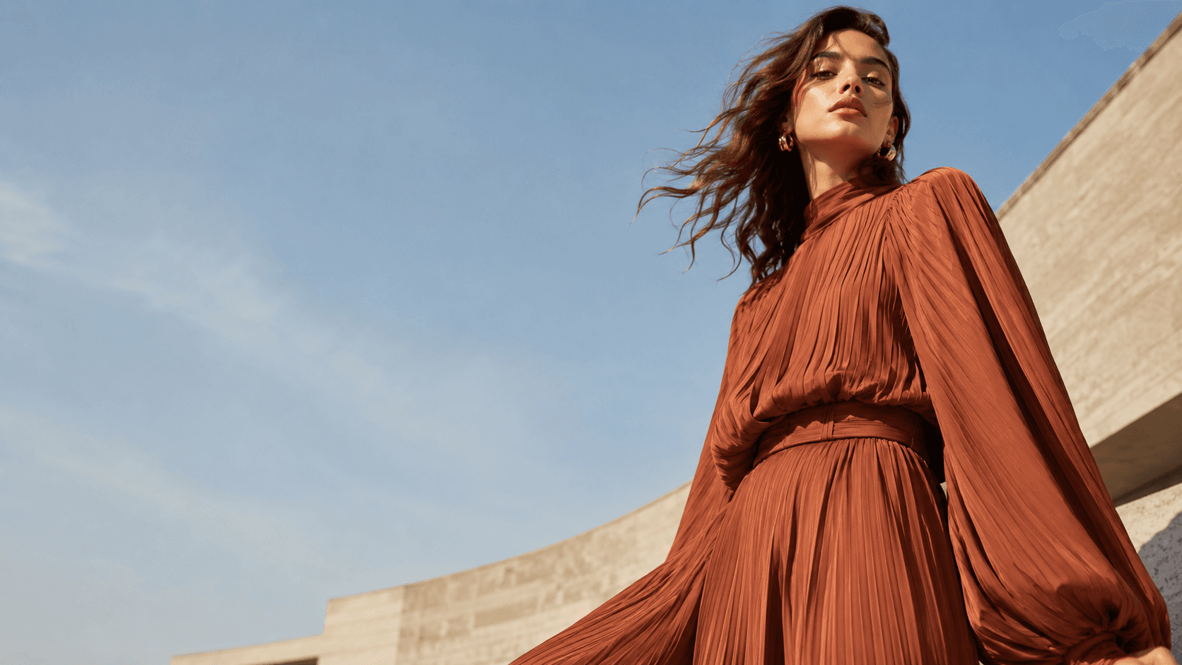 A woman in a rust pleated dress